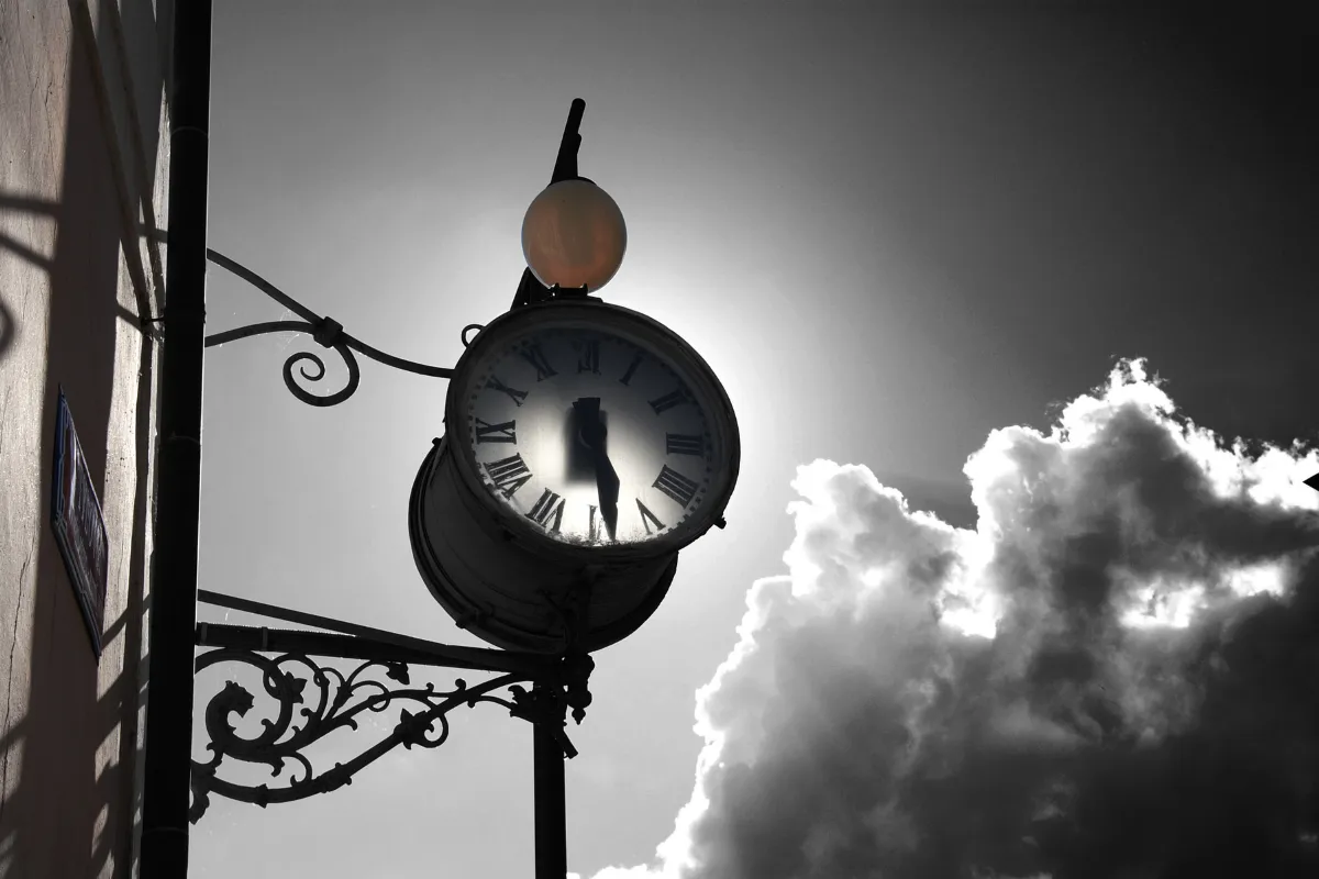 Imagen de un reloj analogo y nubes. Estilo blanco y negro con un toque de rojo